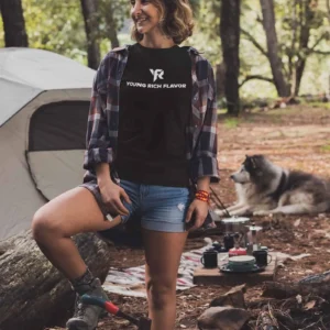 Woman camping with a dog nearby.